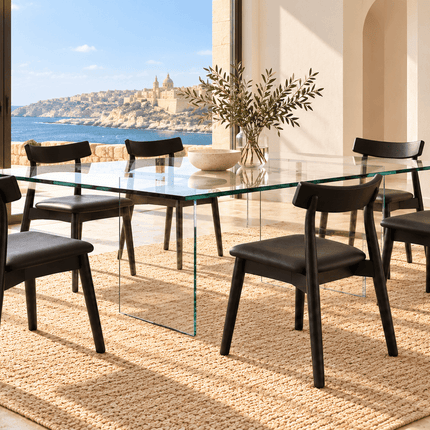 Six black wooden dining chairs with PU leather seats around a glass dining table