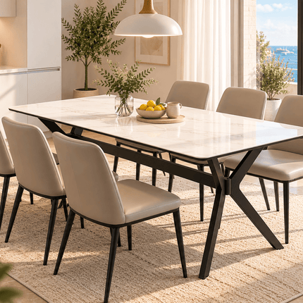 White sintered stone dining table with black metal legs and six beige chairs in a bright Mediterranean-style dining room