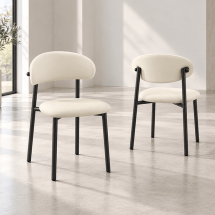 Front and rear views of cream upholstered dining chairs with black metal frames
