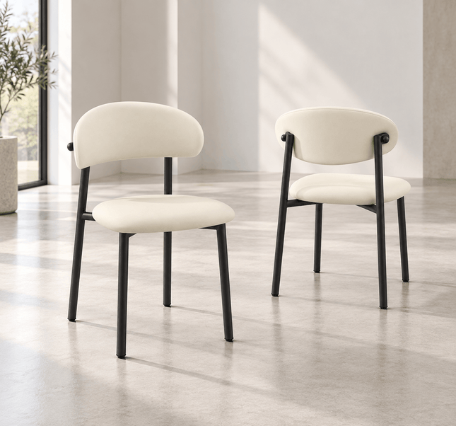 Front and rear views of cream upholstered dining chairs with black metal frames