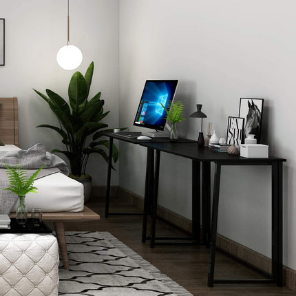 Black folding computer desk used as a workspace in a bedroom