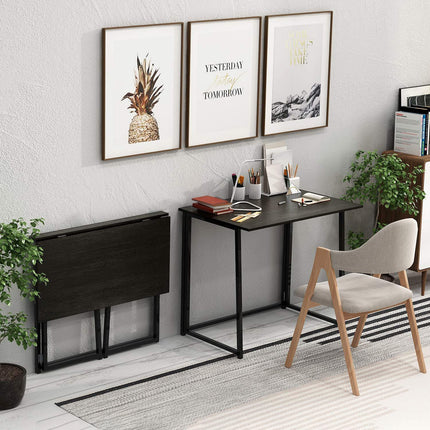 Compact black folding desk in a home office beside a chair