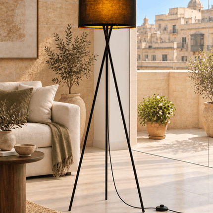 Black tripod floor lamp with fabric shade and warm LED bulb in living room