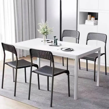 Plastic metal dining chairs around dining table in modern dining room
