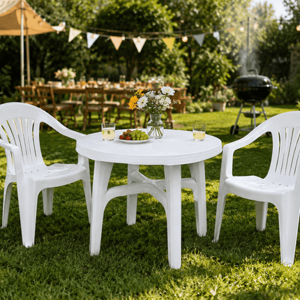 White outdoor garden table and chairs set on grass patio